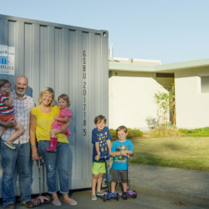 Family standing in front of Storage and Moving Container