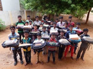 Kids holding donated school supplies