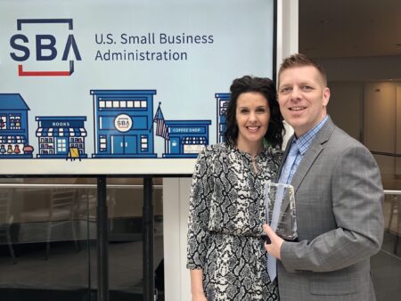 Businessman and woman standing at awards ceremony