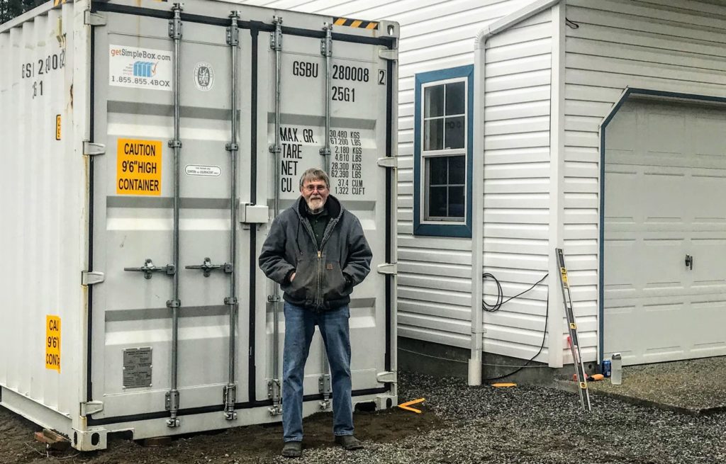 Man standing in front of his newly purchased shipping container.