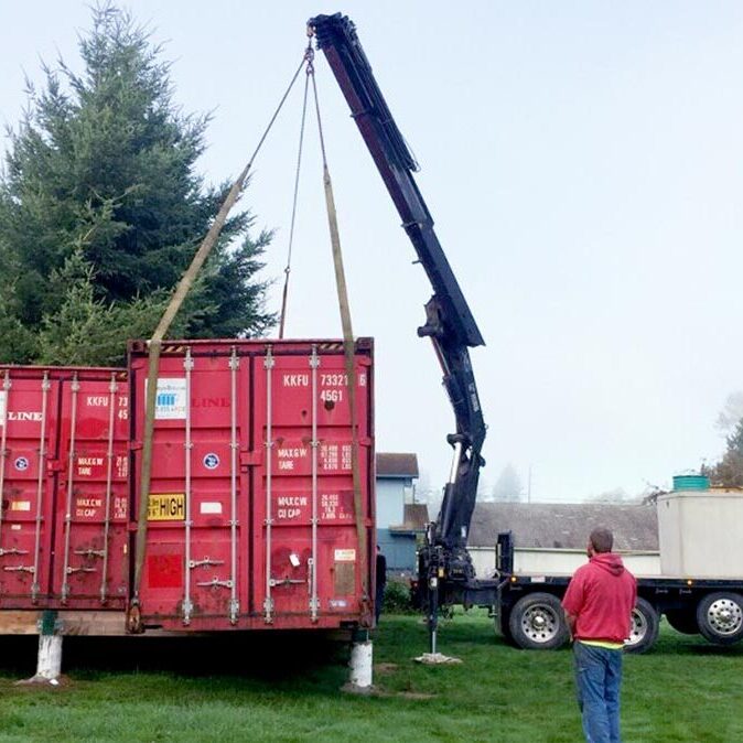 Crane lifting a red shipping container.