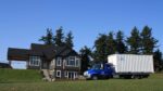 Truck delivers a shipping container to a house.