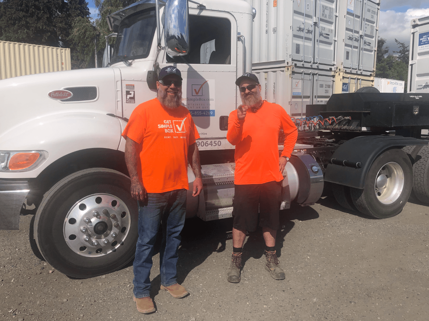 Two drivers from Get Simple Box with an orange shirt getting ready to deliver a small shipping container to someone who wanted to buy a small shipping container.