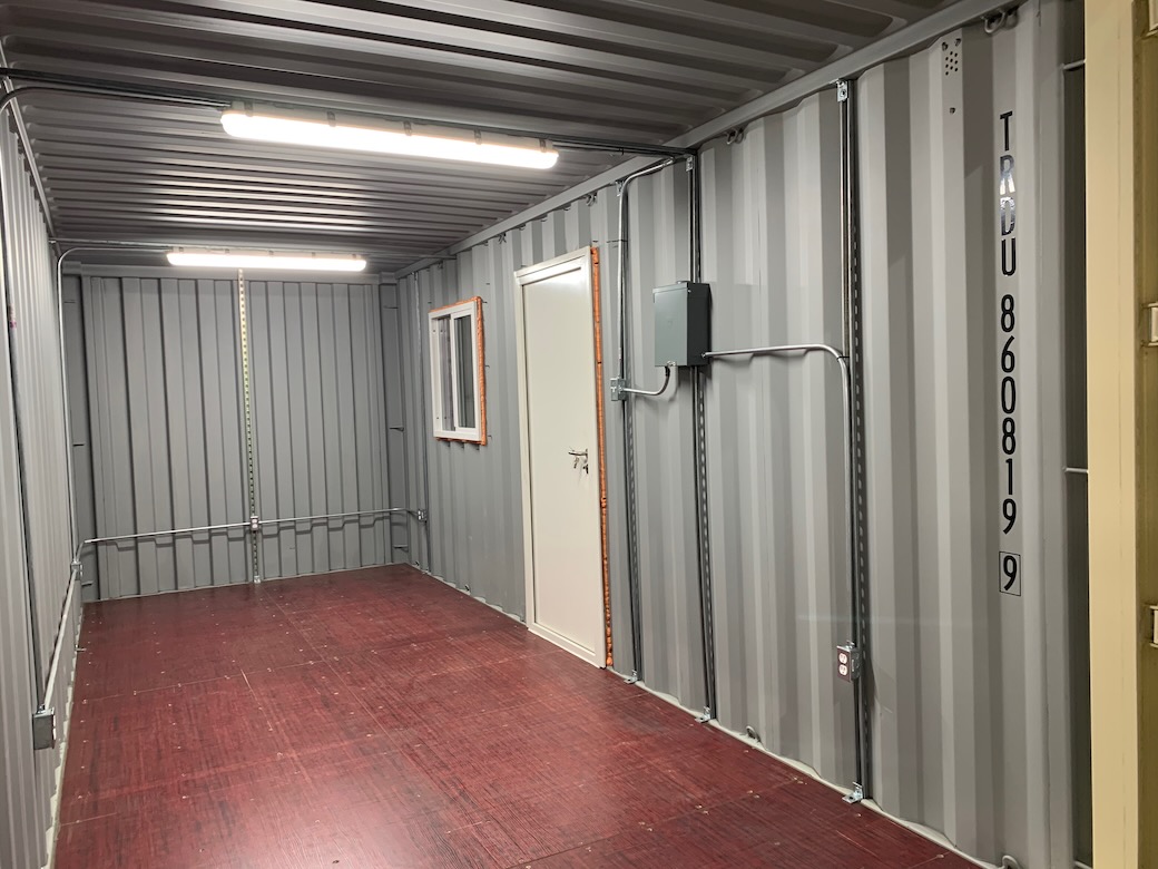 modified shipping container inside with electrical wires and light