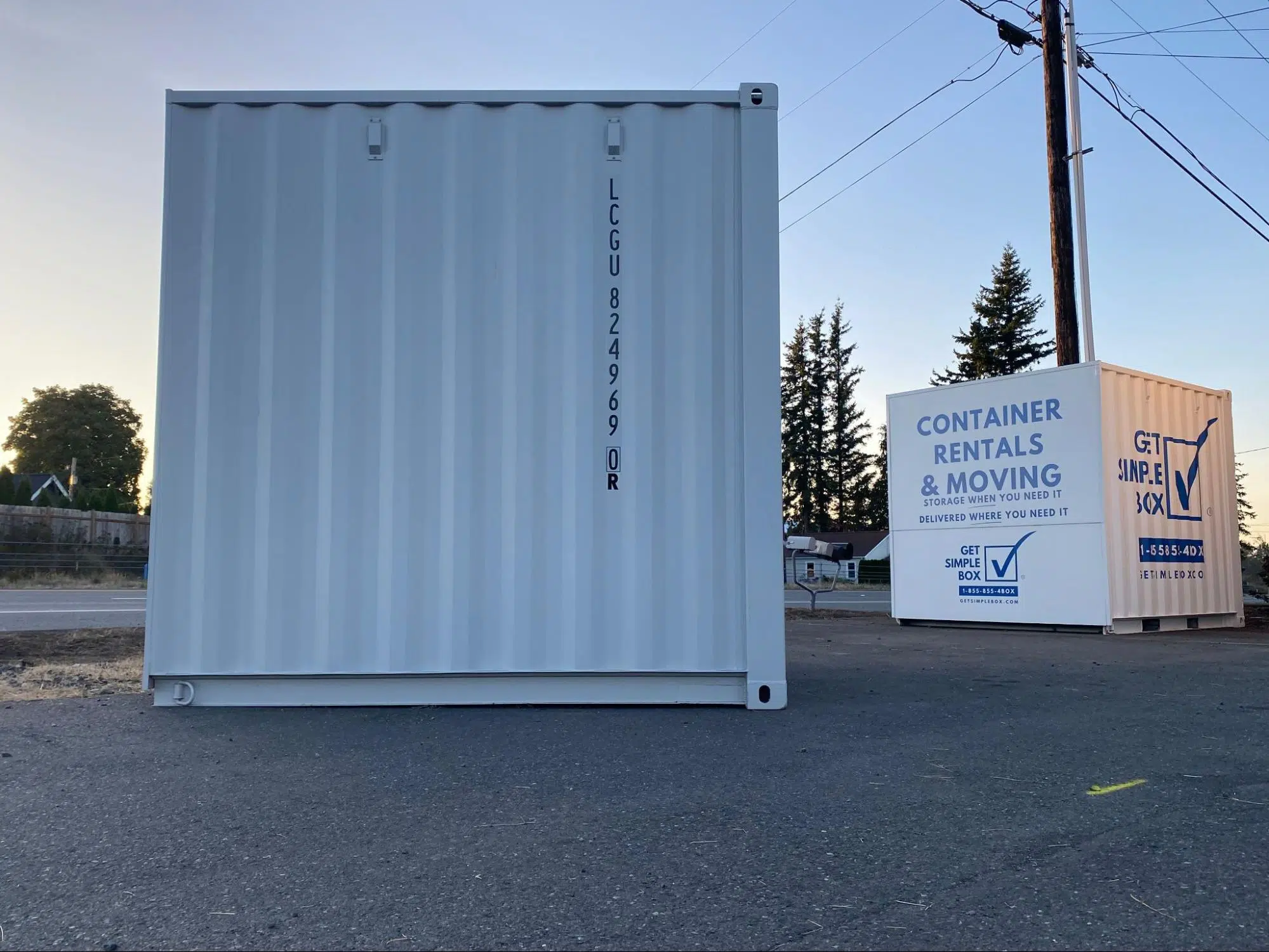 Two 10 foot shipping containers located at a yard and one with a vinyl sign