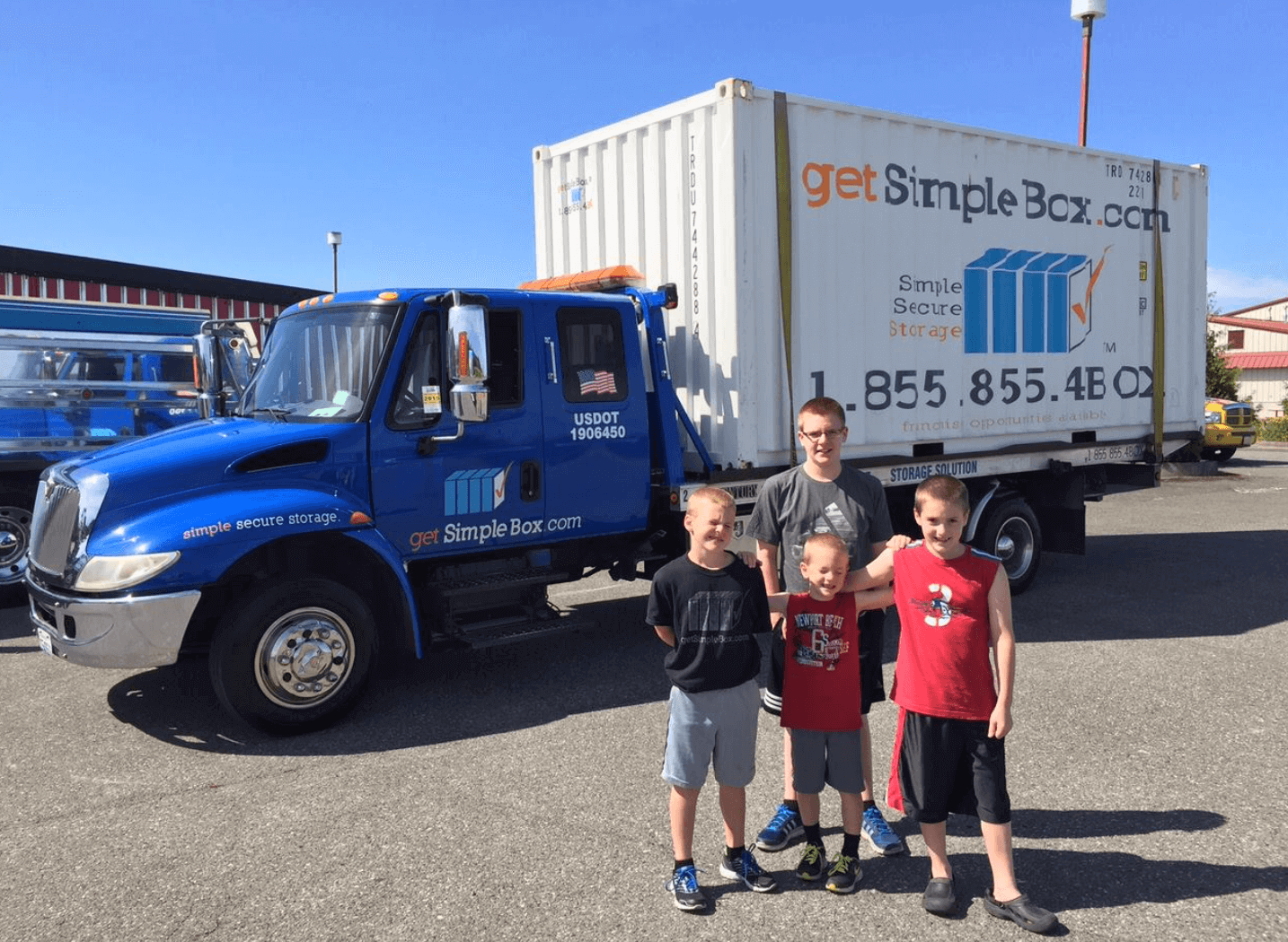 20 foot shipping container loaded in a get simple box truck with three boys.