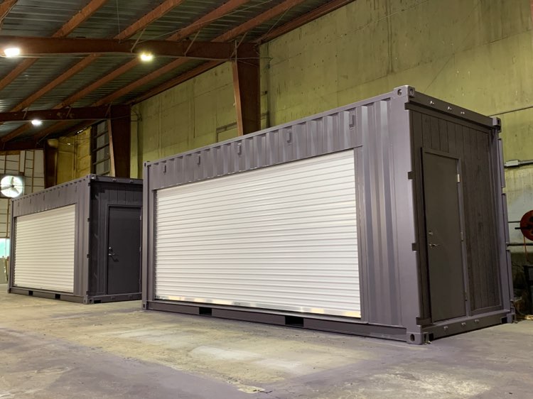 two 20 foot shipping container modifications with roll up doors and black pedestrian doors.