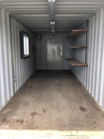 Interior view of a 20ft basic office container ad job box container with rackets, window and electricity