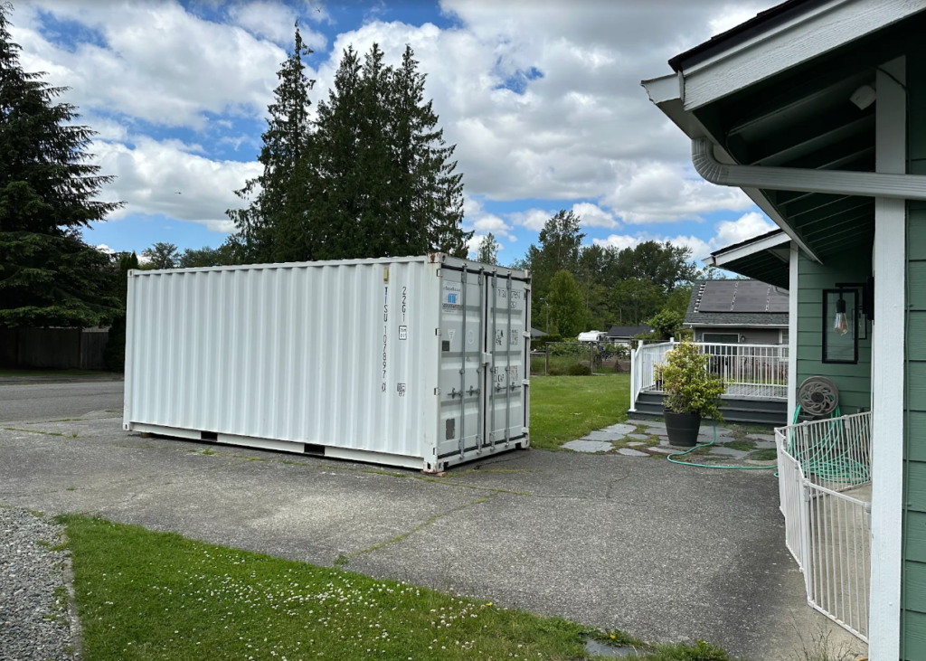 White 20-foot container placed beside a home in La Conner, WA