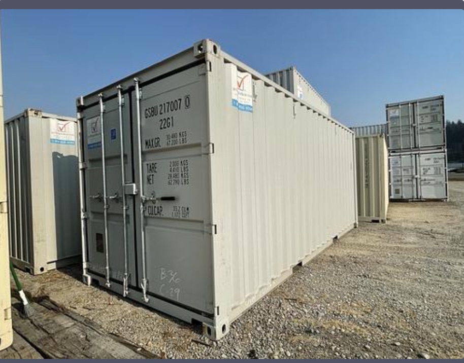 White 20-foot shipping containers lined up on a gravel lot in Burlington, WA