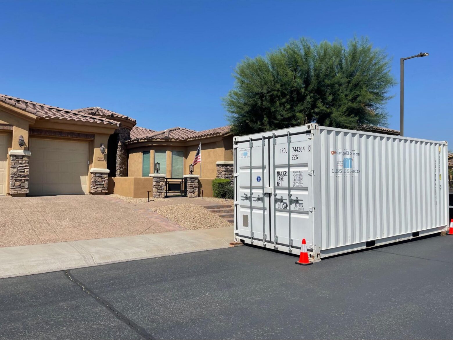 White 20-foot container placed next to a two-car garage