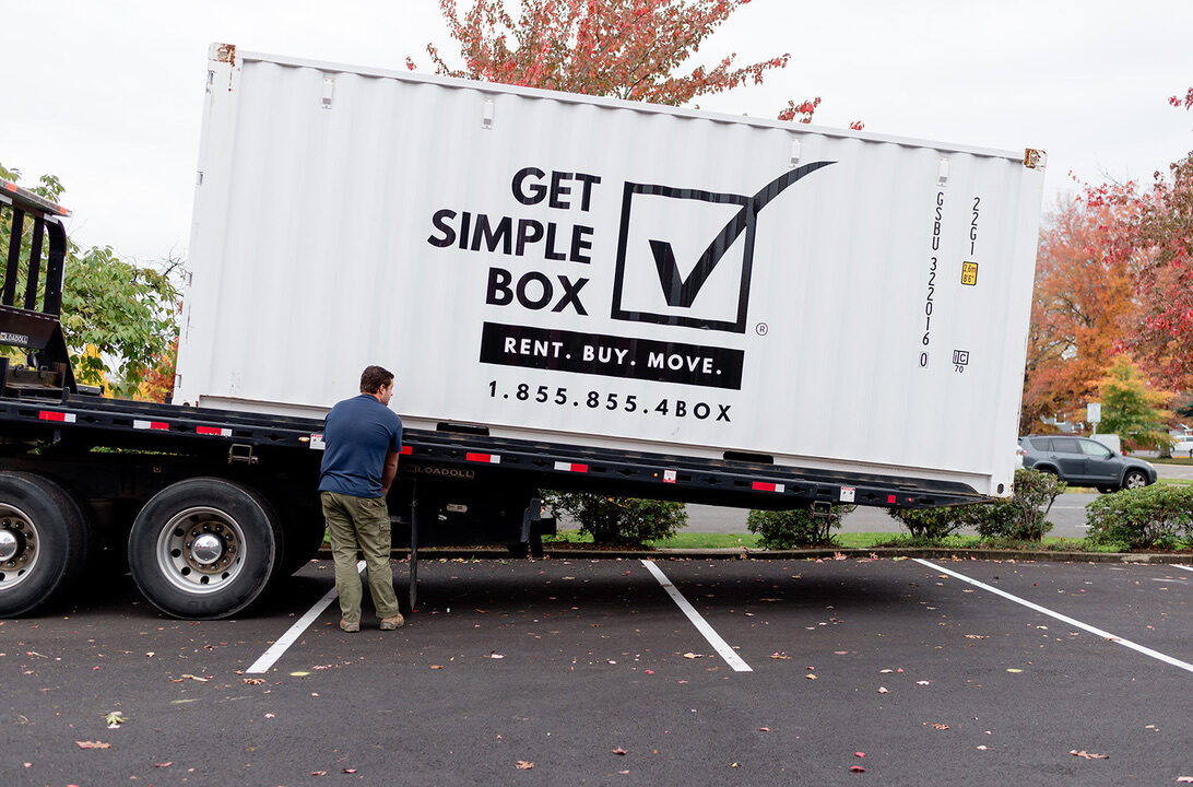 Get Simple Box truck tilting its bed to unload a white 20-foot container