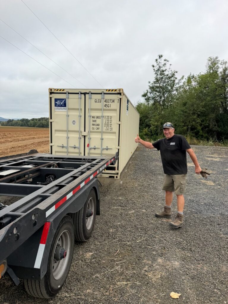 Customer giving a thumbs up next to a tan container on a trailer in La Conner, WA