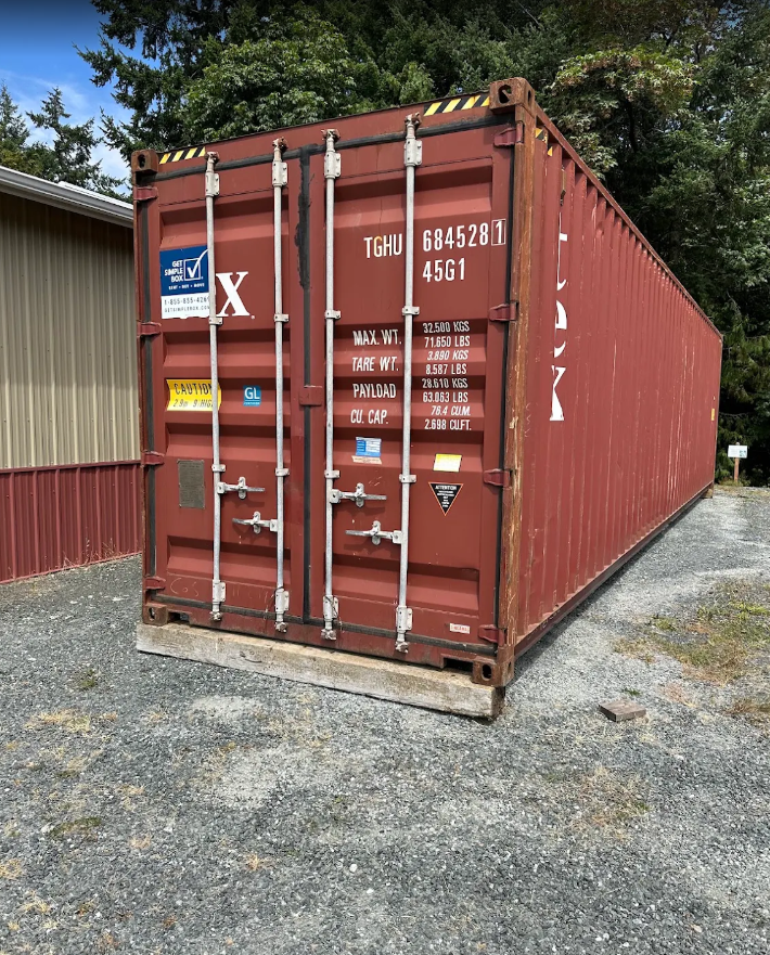 Red shipping container on a gravel lot