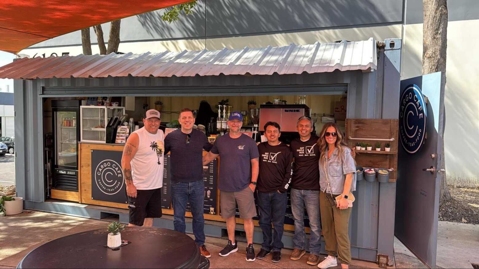 Team of local operators standing in front of a modified container cafe