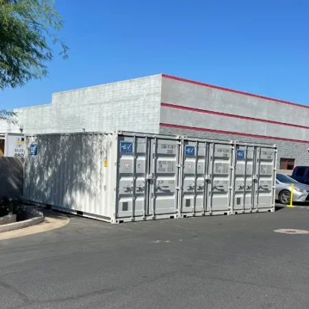 White storage containers lined up outside an apartment building