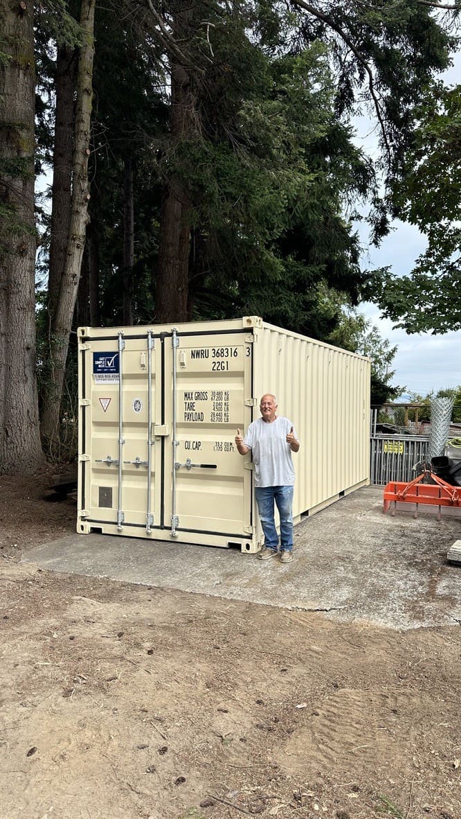 Man next to a tan 20-foot container on a dirt pad in Snohomish, WA