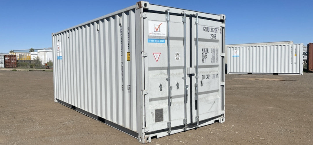 New white 20-foot shipping container on a dirt lot