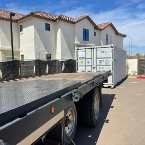 White storage container being delivered beside a residential home