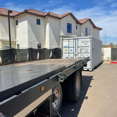 White storage container being delivered beside a residential home