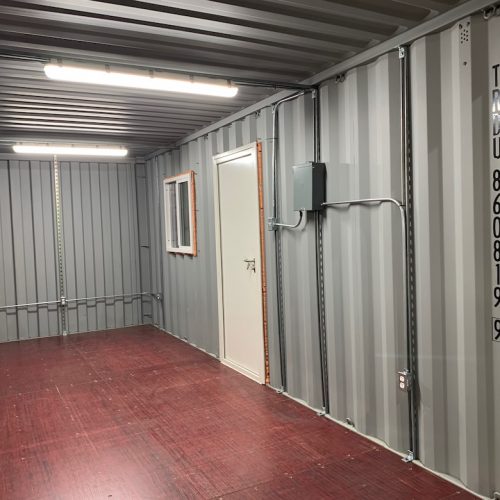 modified shipping container inside with electrical wires and light