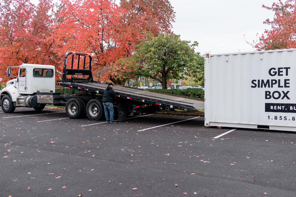 Get Simple Box delivery truck positioned beside a branded storage container